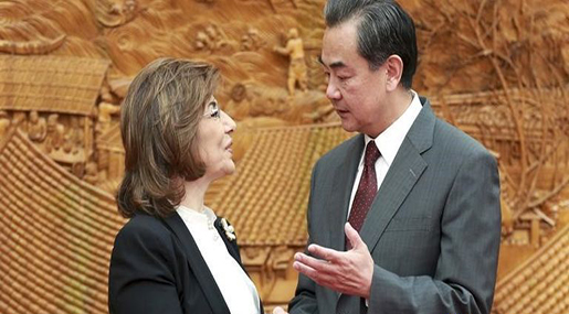 Chinese Foreign Minister Wang Yi gestures as he shakes hands with Syrian government special envoy Bouthaina Shaaban
